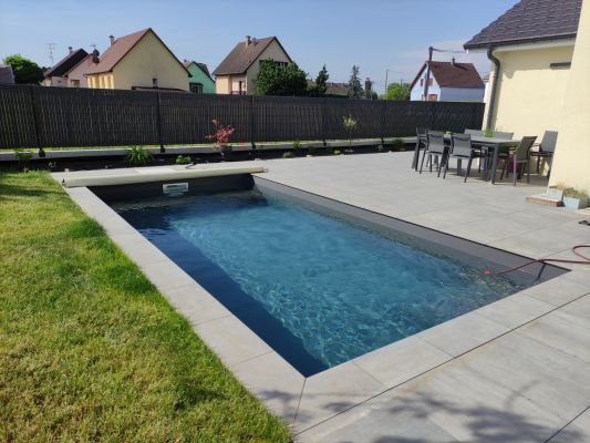 liner de piscine gris clair mis en eau dans jardin